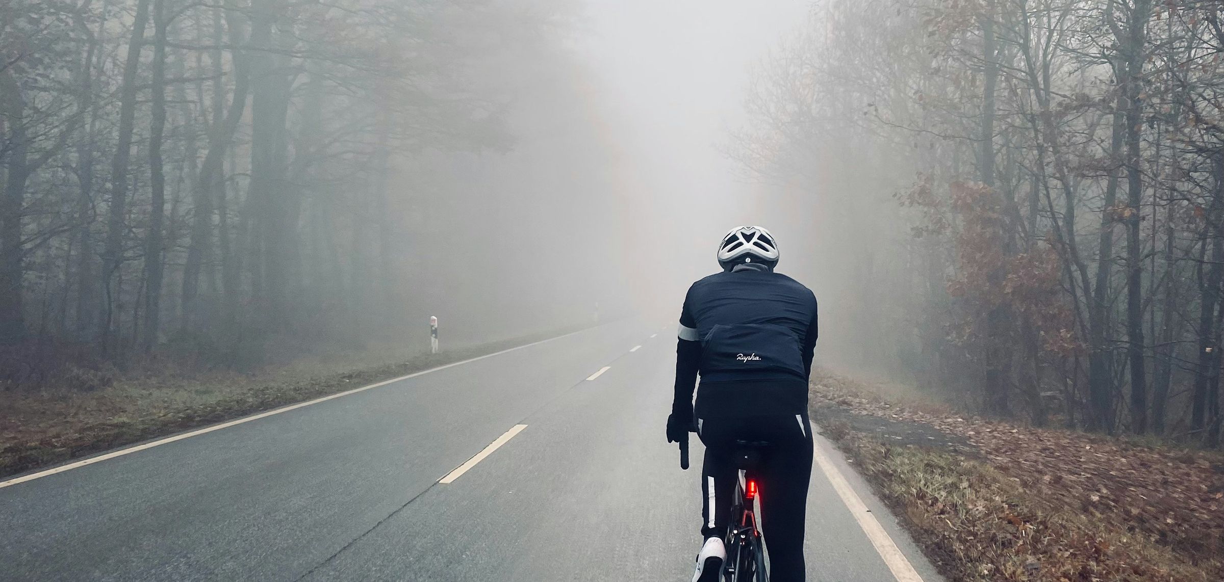 Ein Radfahrer auf einer nebligen Straße